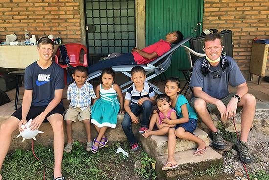 Dr. Bartels posing with children in front of dental station